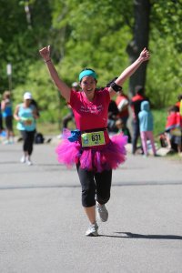 Mei running with her arms in the air at the Women's Half Marathon.