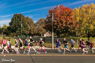 Runners with the leaves on the trees changing colour in the background.